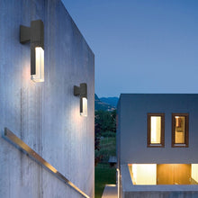 Load image into Gallery viewer, Iguala outdoor wall light installed at rear entrance, showing warm LED glow at night
