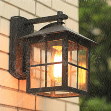 Load image into Gallery viewer, Tepexpan lantern wall light illuminated at night, warm glow on brick exterior wall