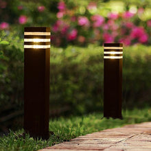 Load image into Gallery viewer, Delicias bollard light H60cm variant illuminated at night, warm white glow on garden path
